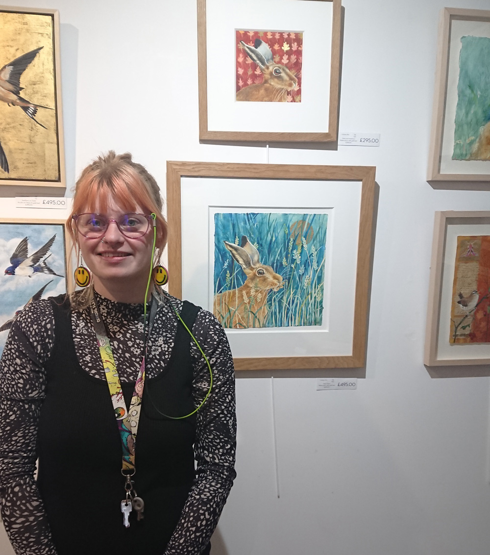 Manager, Lauren McQuaid in front of the animal-themed exhibition