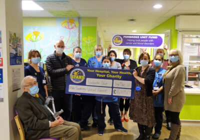 Mike Southway with his dad, John, presenting a cheque for the Stars Appeal to staff at the Pembroke Unit at Salisbury District Hospital