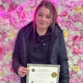 Phoebe Finnerty with her hair extension certificate