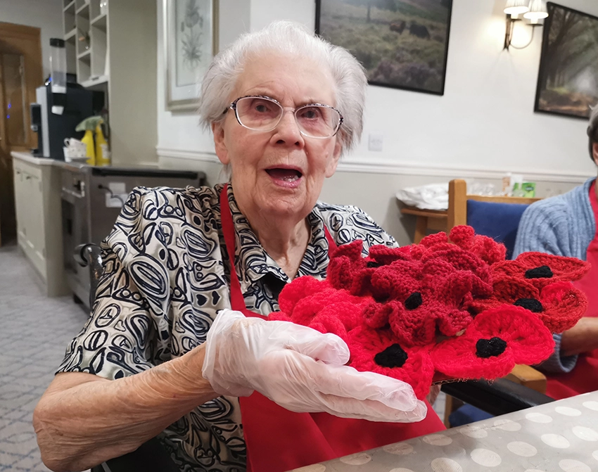 Maureen Miller, who lives at Colten Care’s Woodpeckers care home in Brockenhurst, with a finished wreath made in residents’ arts and crafts sessions