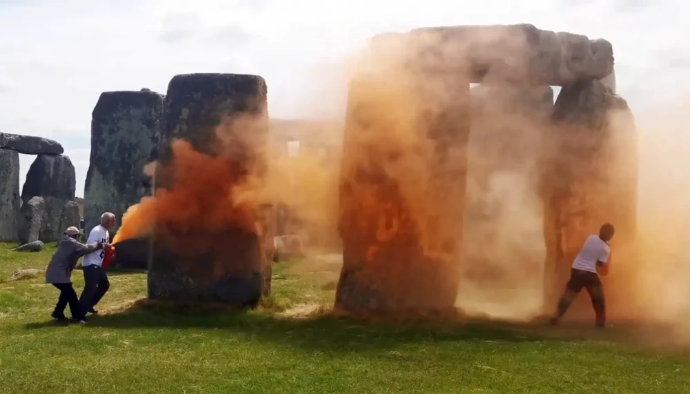 A person tried to stop the Just Stop Oil activists carrying out the attack at Stonehenge. Pictures: JSO