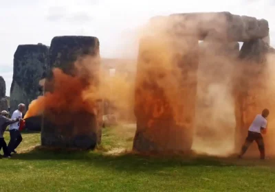A person tried to stop the Just Stop Oil activists carrying out the attack at Stonehenge. Pictures: JSO