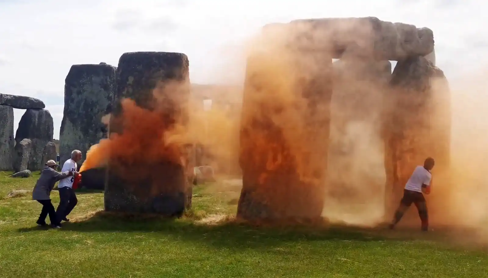 A person tried to stop the Just Stop Oil activists carrying out the attack at Stonehenge. Pictures: JSO