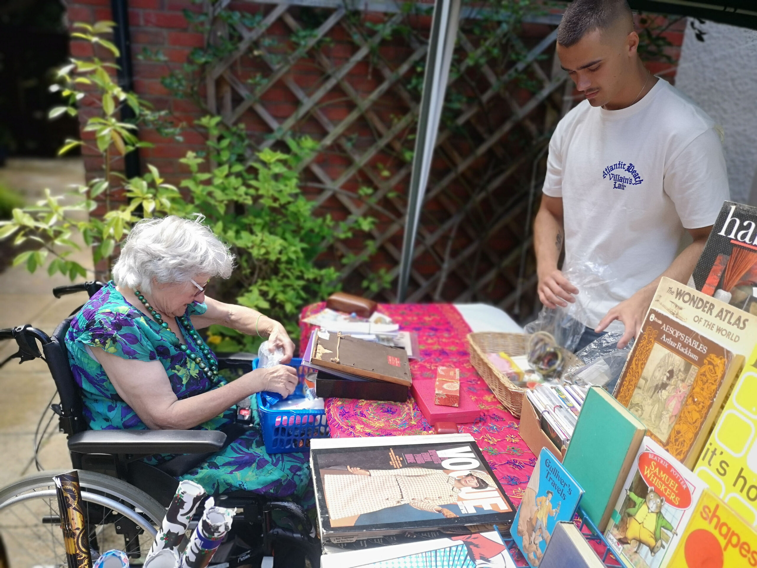 Braemar Lodge resident Catherine Brighty prepares her own stall in readiness for visitors to the garden party. With her is helper Jamie, son of Companionship Team member Kelly Bartlett Picture: Colten Care