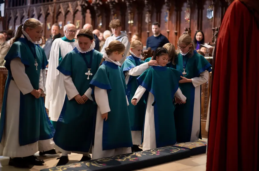 Phoebe Yuan Richards is given her tabard by senior choristers Picture: Finnbarr Webster