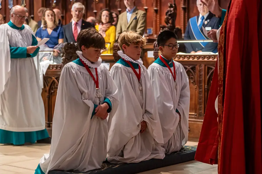 Senior Choristers kneel during the service after being presented their medals Picture: Max Willcock BNPS