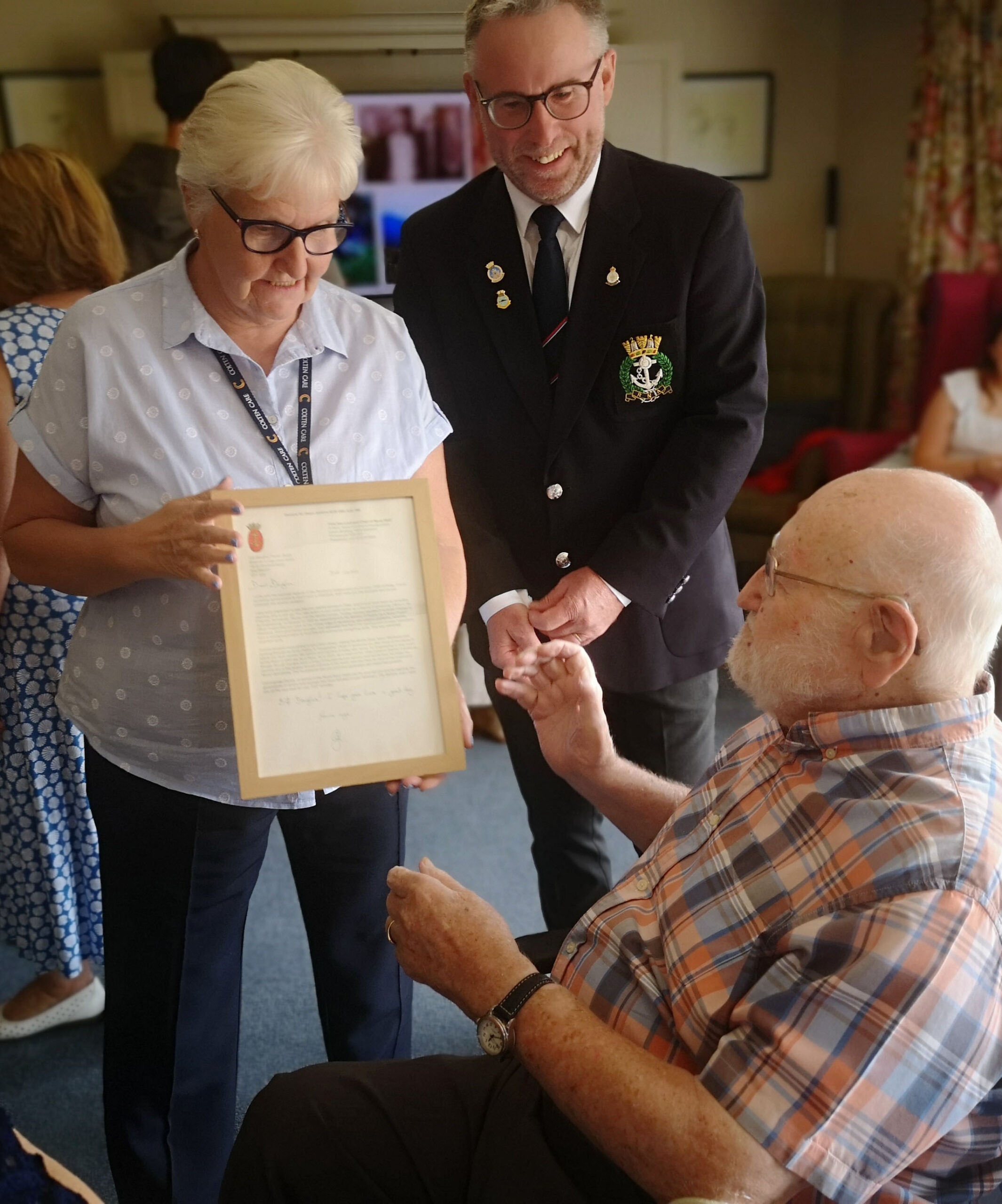 Douglas Parish receives 100th birthday greetings in a framed letter from the First Sea Lord, presented by Jackie Cash and Jon Everett Picture: Braemar Lodge 