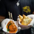 Person wearing gloves holds takeaway food