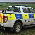 A Wiltshire Police 4x4 pickup truck in a muddy field